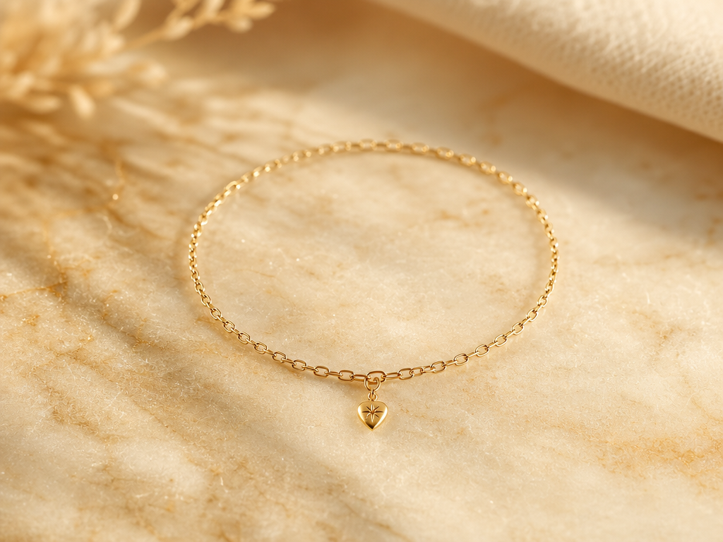 Massives Gold-Permanent Bracelet mit Charm auf Marmor