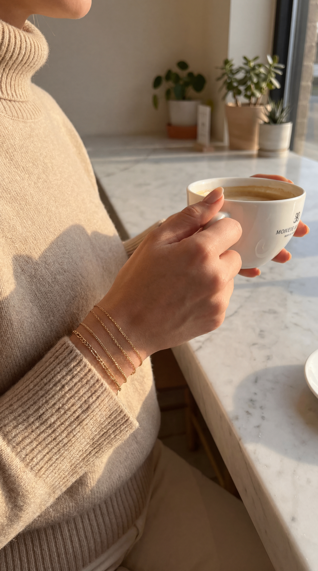 Drei Goldketten übereinander am Handgelenk beim Kaffeetrinken